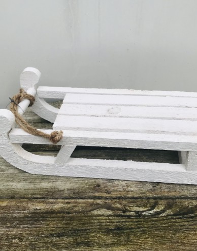 Dekorativer weißer Holzschlitten
